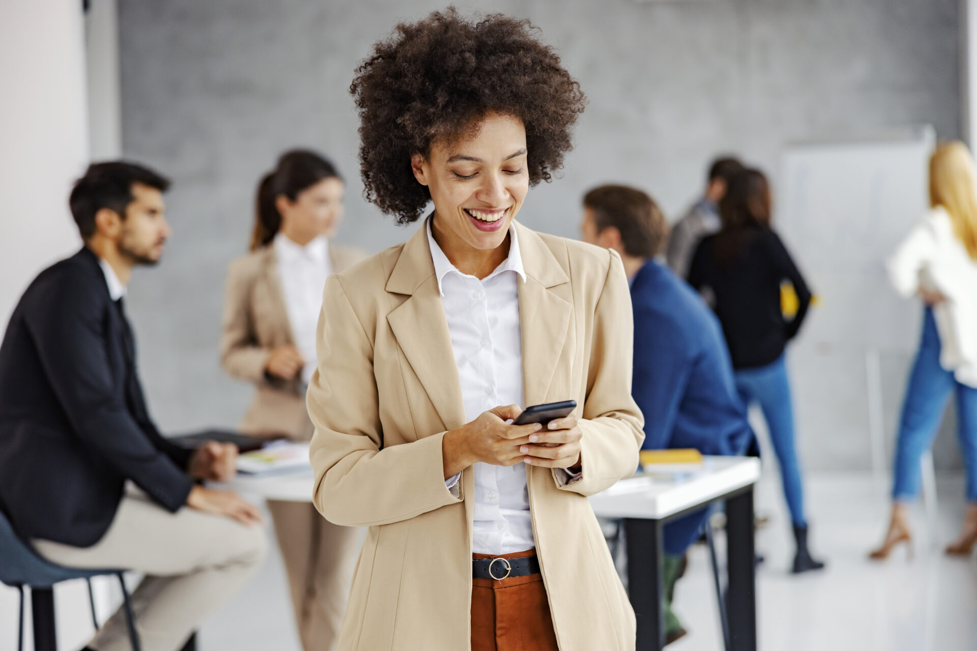 african-american-businesswoman-reading-messages-smiling-phone-office.jpg