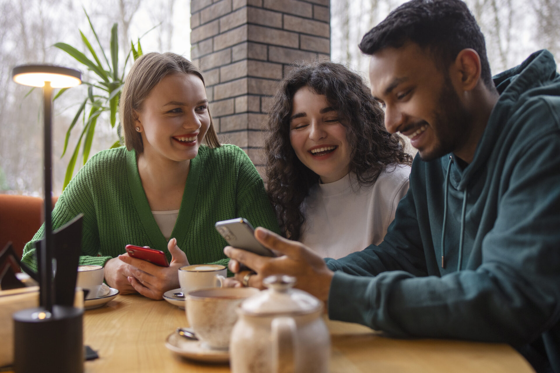 medium-shot-smiley-friends-with-smartphone.jpg